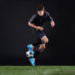 Full length studio shot of a handsome young soccer player isolated on black
