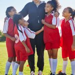 Soccer, girl team coach and happiness with hug, smile and team building, diversity and solidarity o